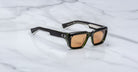 Jacques Marie Mage Walker rectangular black sunglasses with light brown lenses shown from above.
