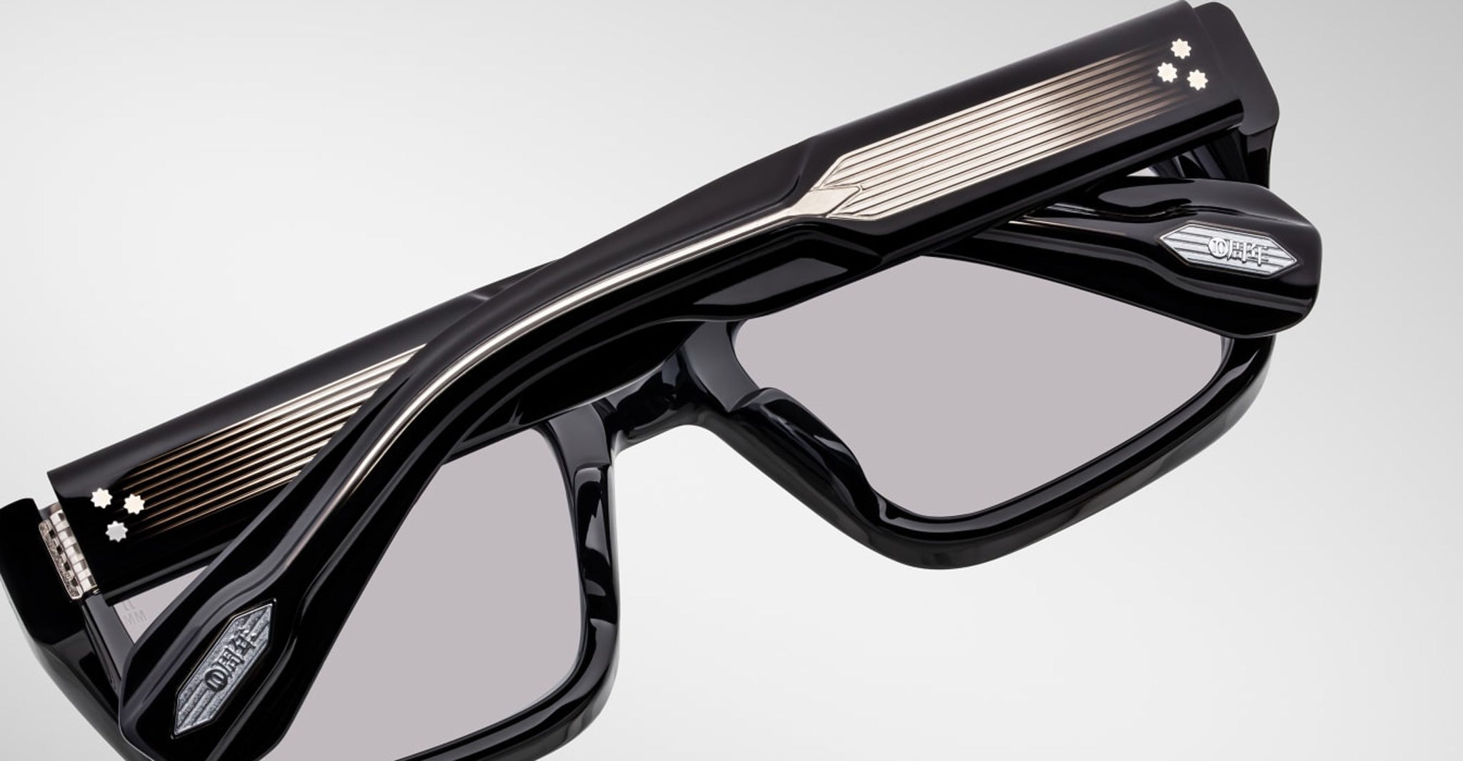 Close-up of Jacques Marie Mage Walker eyeglasses in black with metallic accents, showing frame tech details. Front angle view.