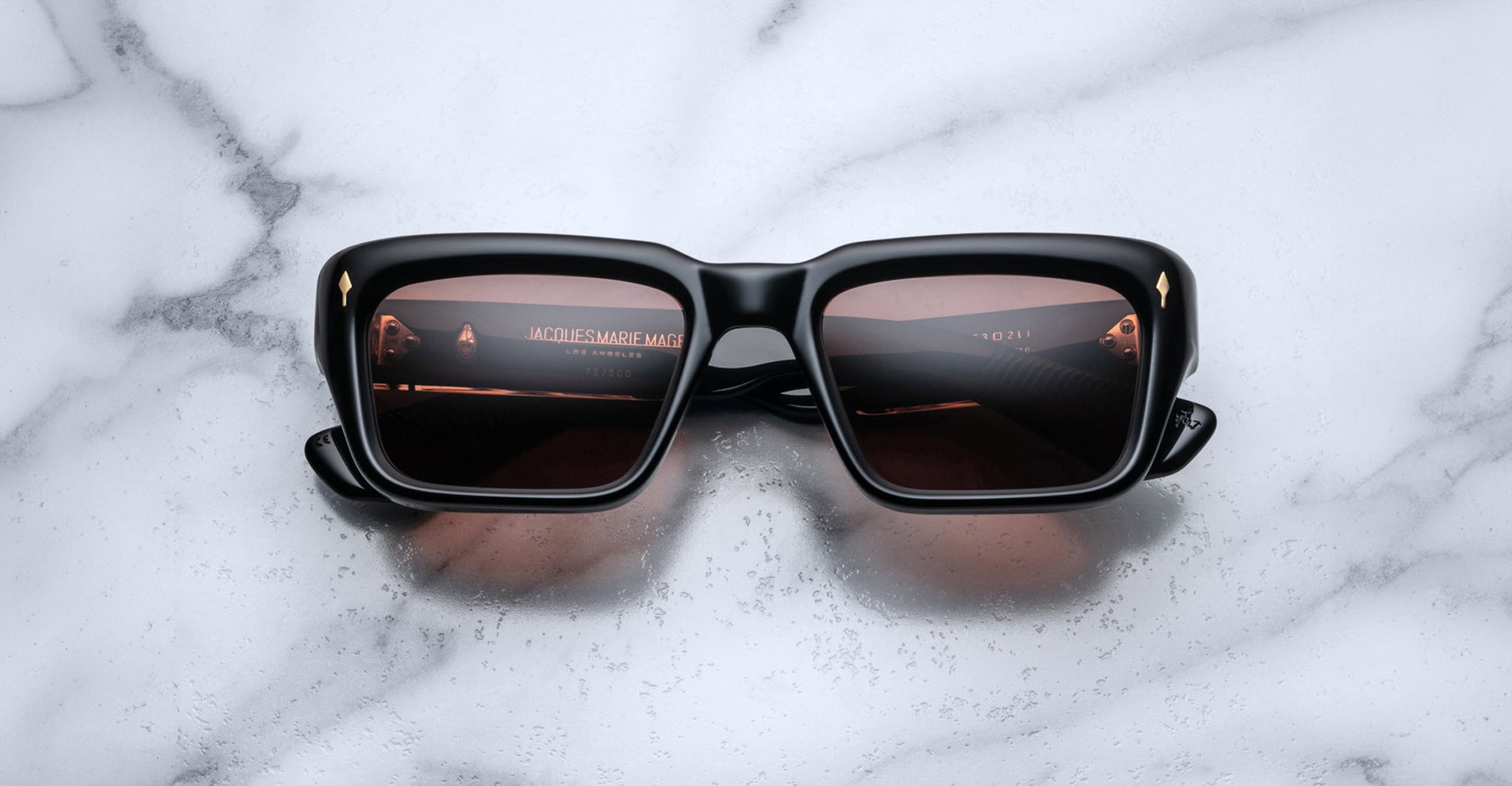 Jacques Marie Mage Walker black sunglasses with brown lenses, front view, lenses reflecting a movie title.