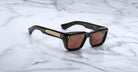 Jacques Marie Mage Walker black rectangular sunglasses with gold-accented arms, top view.