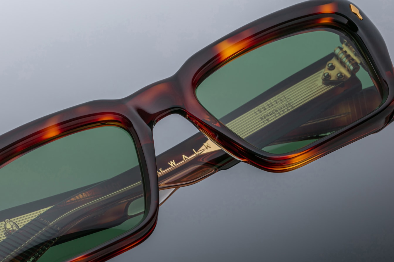 Close-up of Jacques Marie Mage Walker rectangular sunglasses, tortoiseshell frames, green lenses, and gold temple accents.