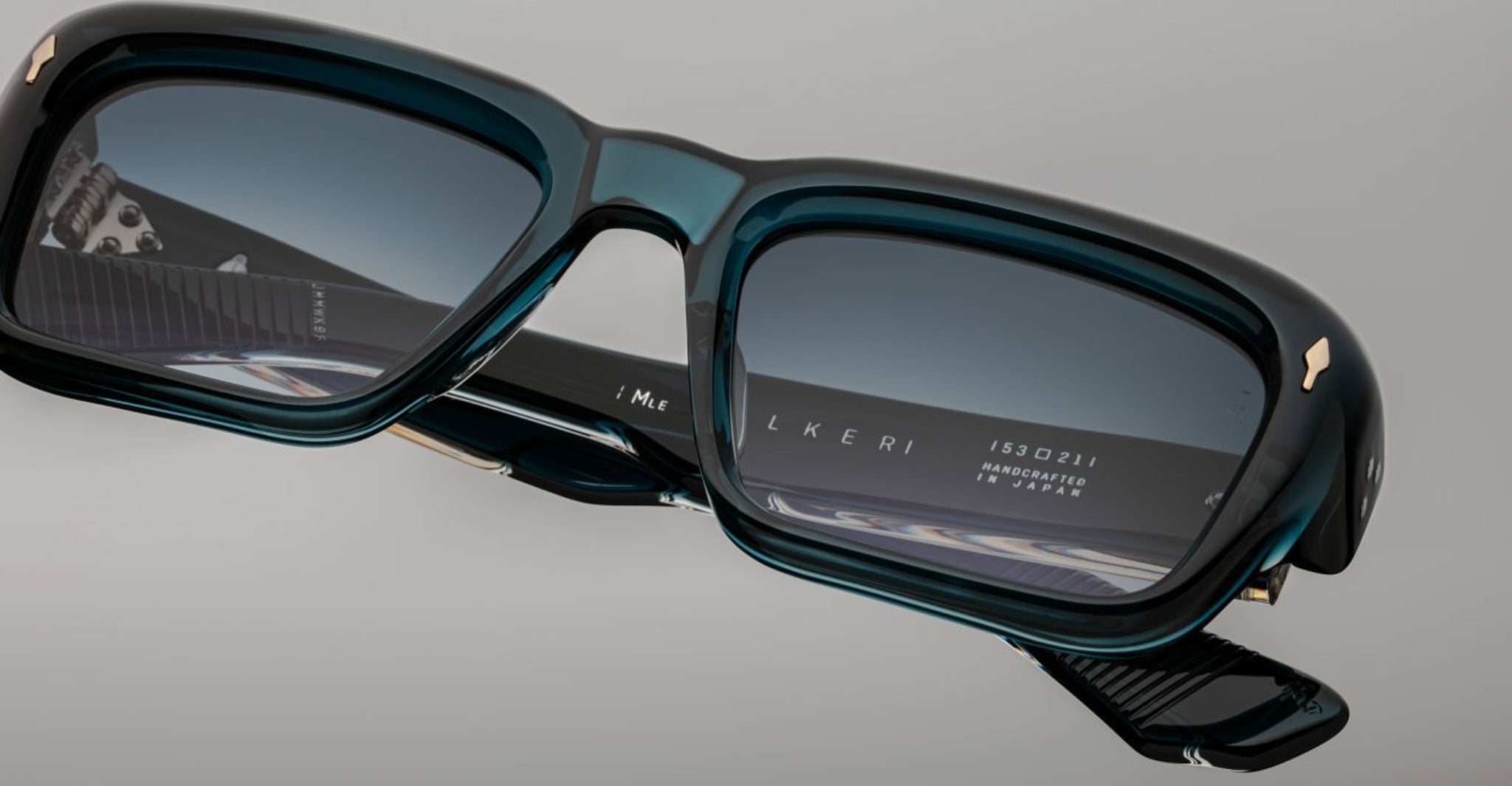 Close-up of Jacques Marie Mage Walker sunglasses showing thick acetate frames and visible inner arm inscriptions, front angle view.