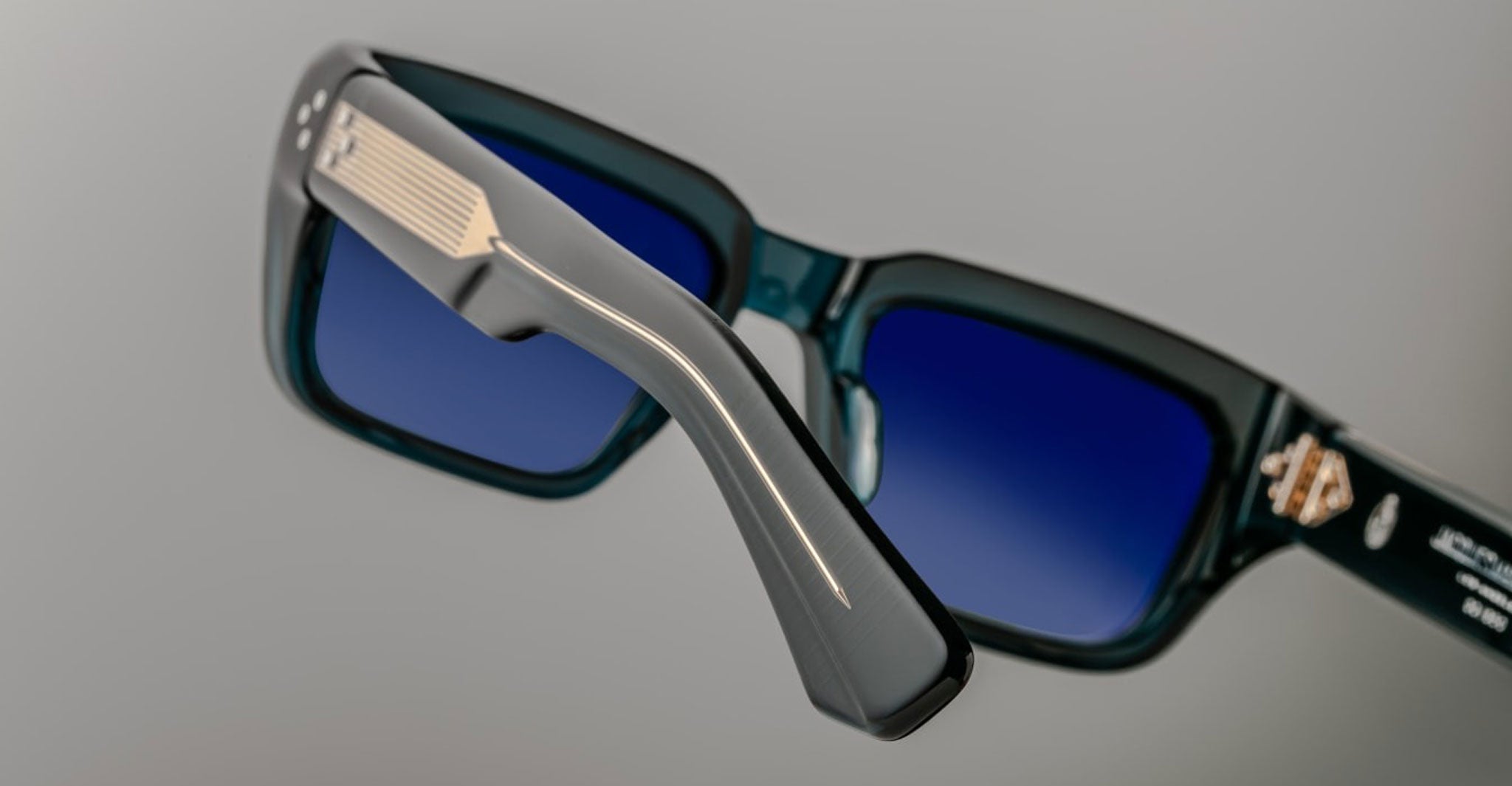 Close-up of Jacques Marie Mage Walker sunglasses, featuring thick dark blue frames and polarized gradient blue lenses.