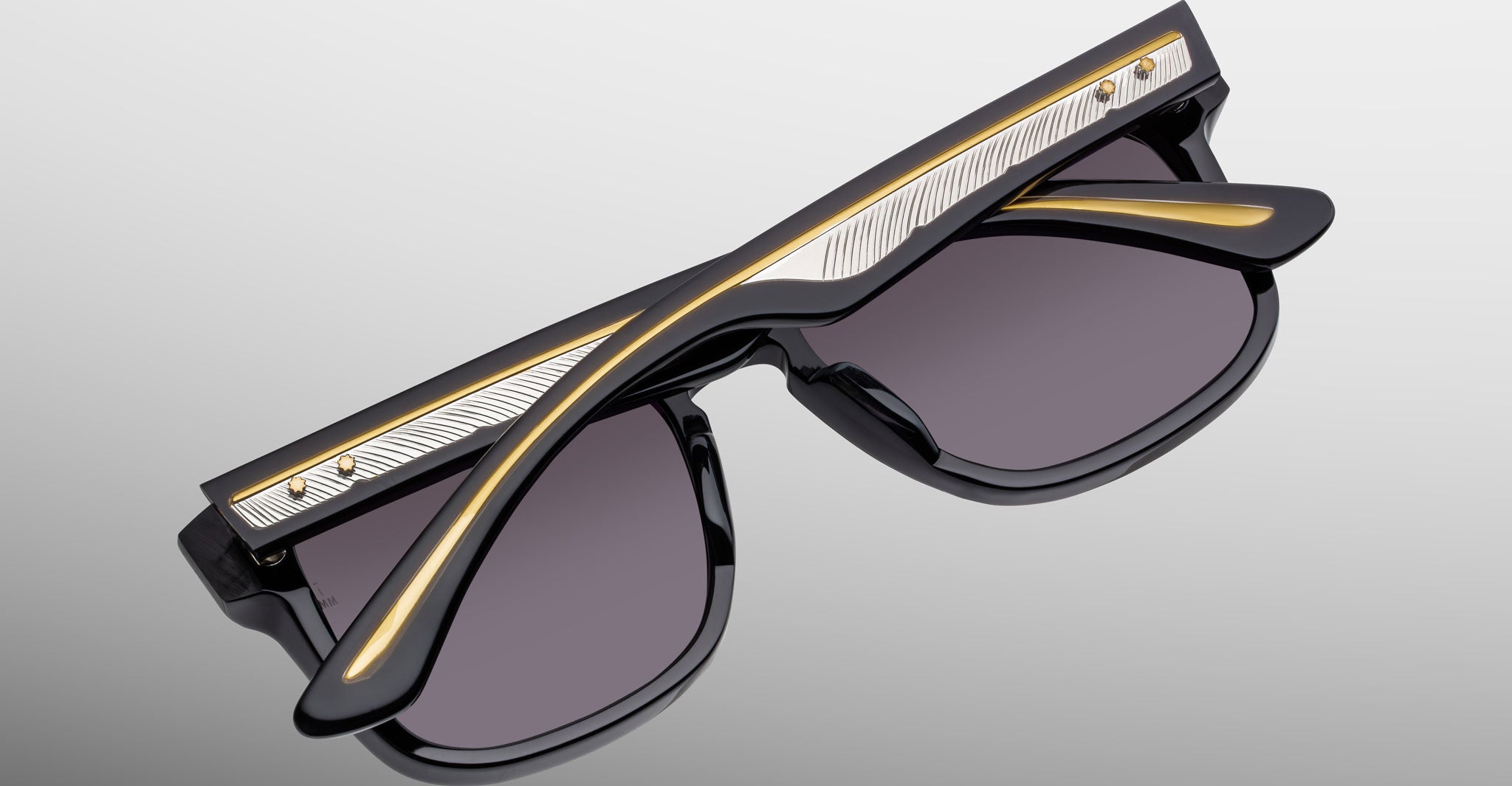 Jacques Marie Mage Wesley sunglasses with gold accents shown upside down, front frame and temples visible.