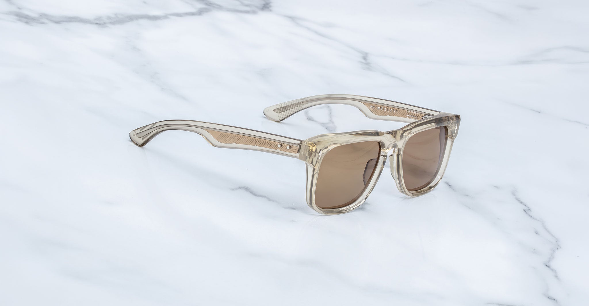 Jacques Marie Mage Wesley square clear-frame sunglasses with brown UV lenses, top-down angle.