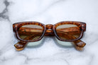 Jacques Marie Mage Whiskeyclone tortoiseshell rectangular sunglasses with green UV-protected lenses, front view.
