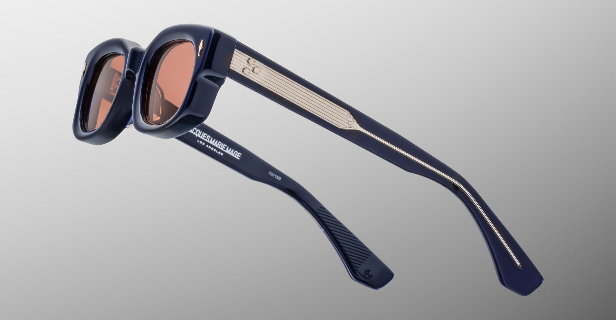 Jacques Marie Mage Whiskeyclone in Minuit sunglasses, deep navy blue acetate frame with rose-tinted lenses, signature silver-tone arrowhead rivets, and intricately engraved silver-tone metal core temples with three-dot detailing, shown from a rear side angle highlighting the sculpted frame and Jacques Marie Mage branding on the inner temple