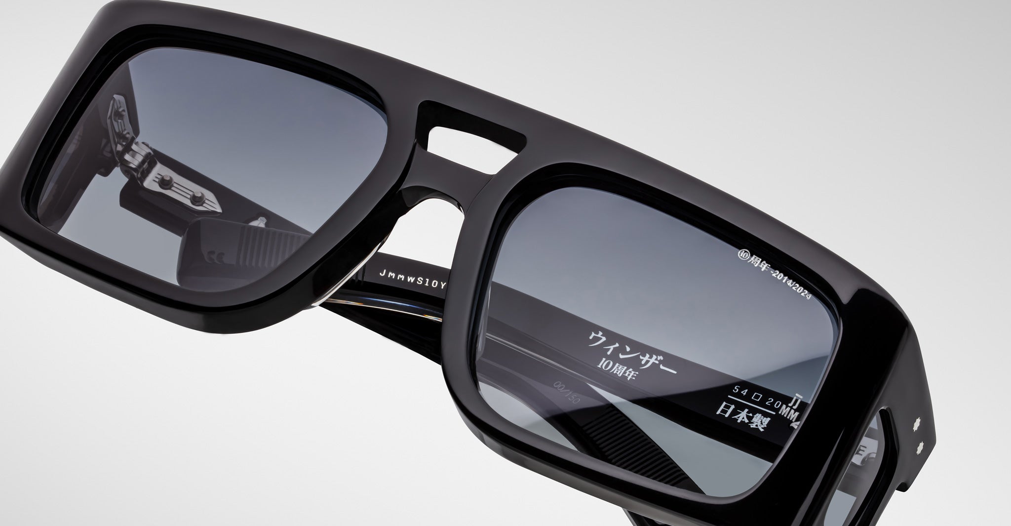 Close-up of Jacques Marie Mage Windsor black rectangular sunglasses with thick frame and mirrored lenses, Japanese text visible.