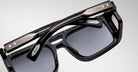 Close-up of Jacques Marie Mage Windsor sunglasses, black thick frames, silver accents, dark tinted lenses, front view.