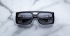 Jacques Marie Mage Windsor black rectangular sunglasses with dark lenses, shown from above.