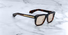 Jacques Marie Mage Yves square tortoiseshell sunglasses with gold-accented arms, shown from above.