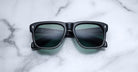 Jacques Marie Mage Yves black rectangular sunglasses with green lenses, shown from above.