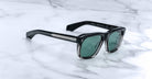 Jacques Marie Mage Yves black rectangular sunglasses with green lenses, front view.