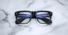 Jacques Marie Mage Yves black rectangular eyeglasses with glossy lenses, front view.