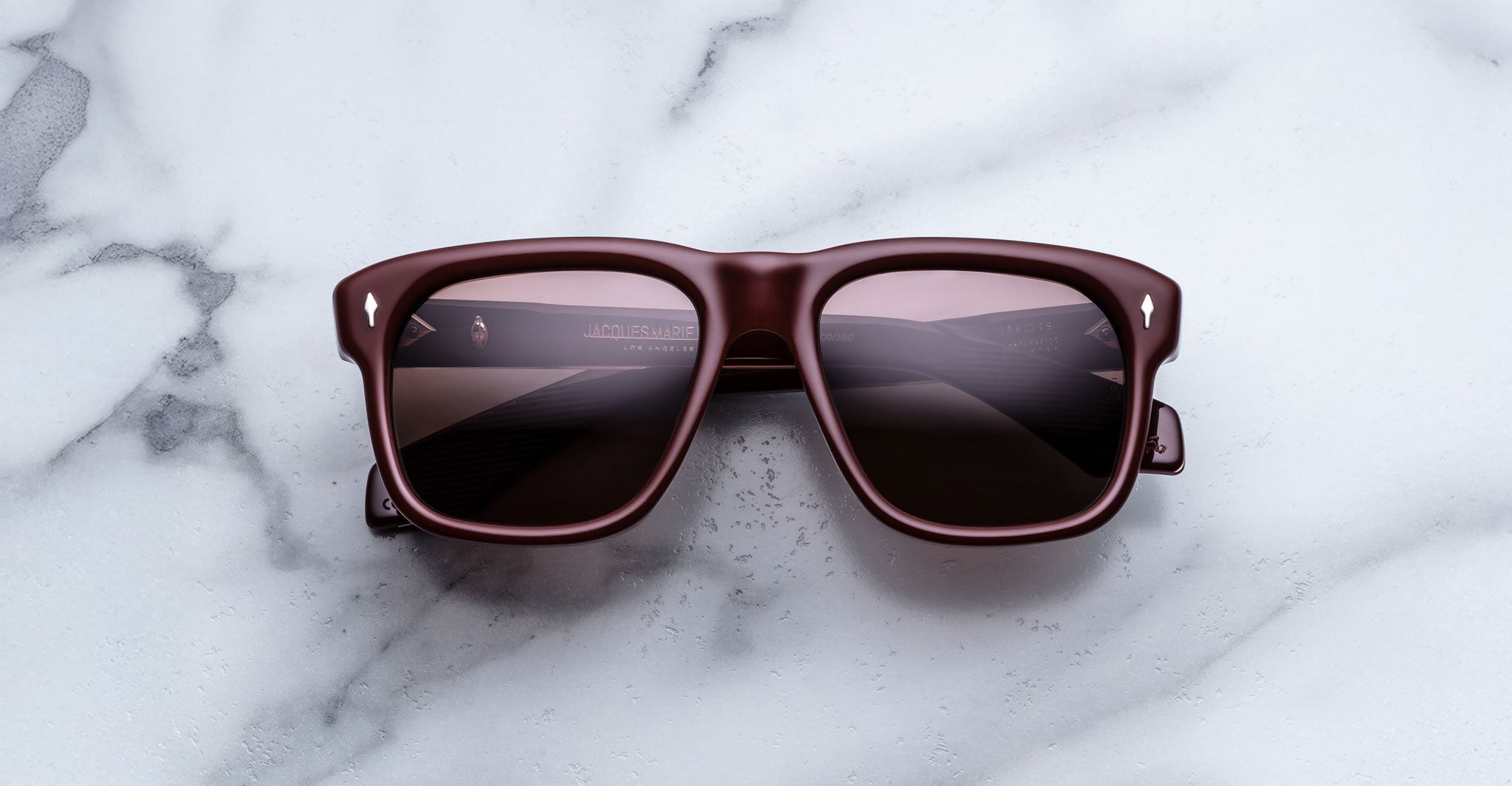 Jacques Marie Mage Yves in Bordeaux Empire sunglasses, rectangular deep red acetate frame with rose-tinted lenses and signature arrowhead rivets, front view