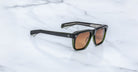 Jacques Marie Mage Yves black rectangular sunglasses with brown lenses, top view.