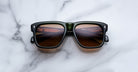 Jacques Marie Mage Yves black sunglasses with brown lenses, top view showing piano key reflections.