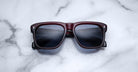 Jacques Marie Mage Yves sunglasses with square maroon frames and polarized dark lenses, front view.