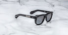 Jacques Marie Mage Yves black rectangular sunglasses with thick frames, shown from above.