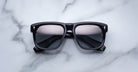 Jacques Marie Mage Yves black rectangular sunglasses with tinted lenses, top view.