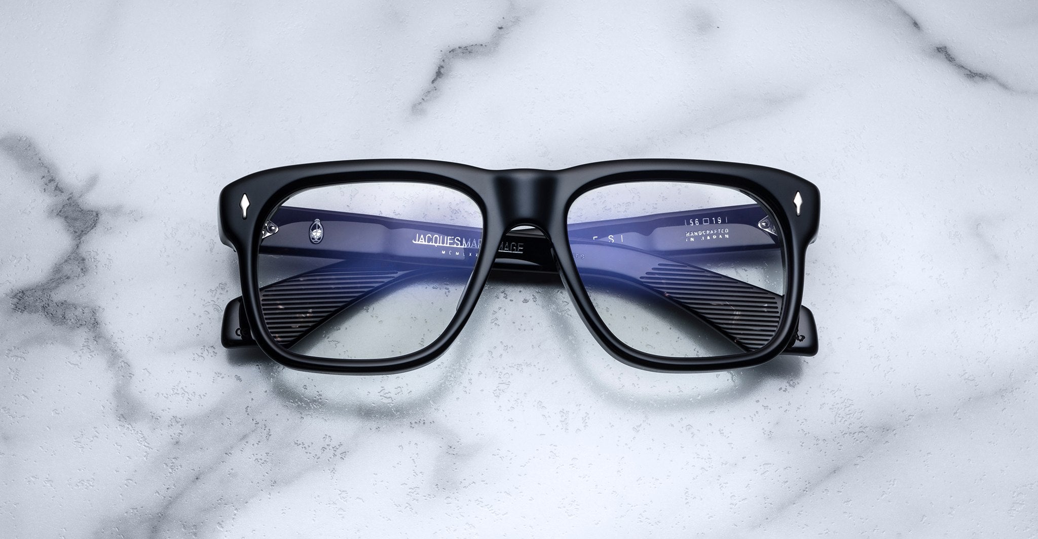 Jacques Marie Mage Yves black rectangular eyeglasses with clear lenses, viewed from above.