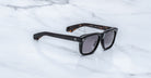 Jacques Marie Mage Yves black rectangular sunglasses with UV-protective lenses, top view.