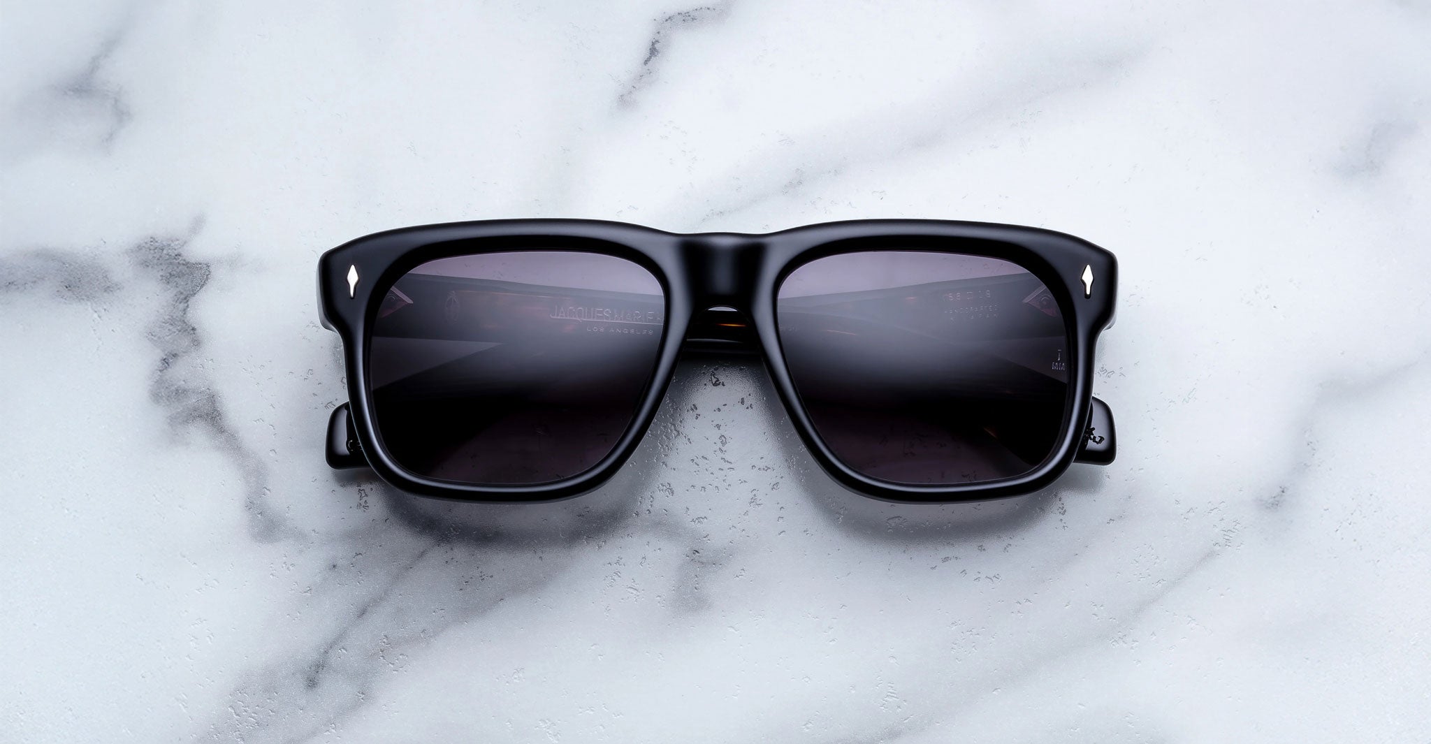 Jacques Marie Mage Yves sunglasses with dark lenses, top view, showing thick frames and branded design.
