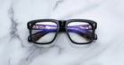 Jacques Marie Mage Yves black eyeglasses with thick frames, front view showing lens reflections.