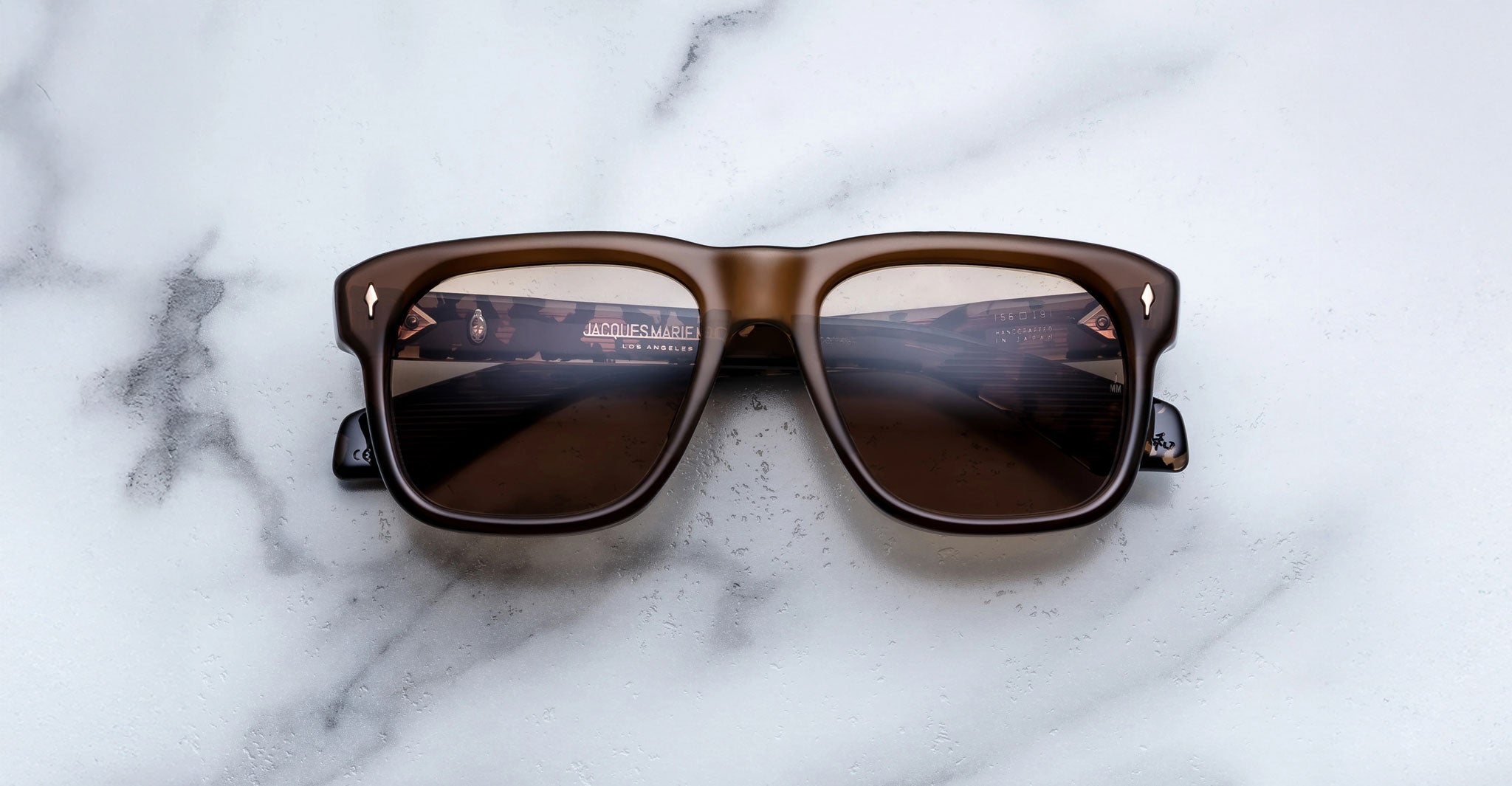 Jacques Marie Mage Yves brown square sunglasses, front view, with cityscape reflected in polarized dark lenses.