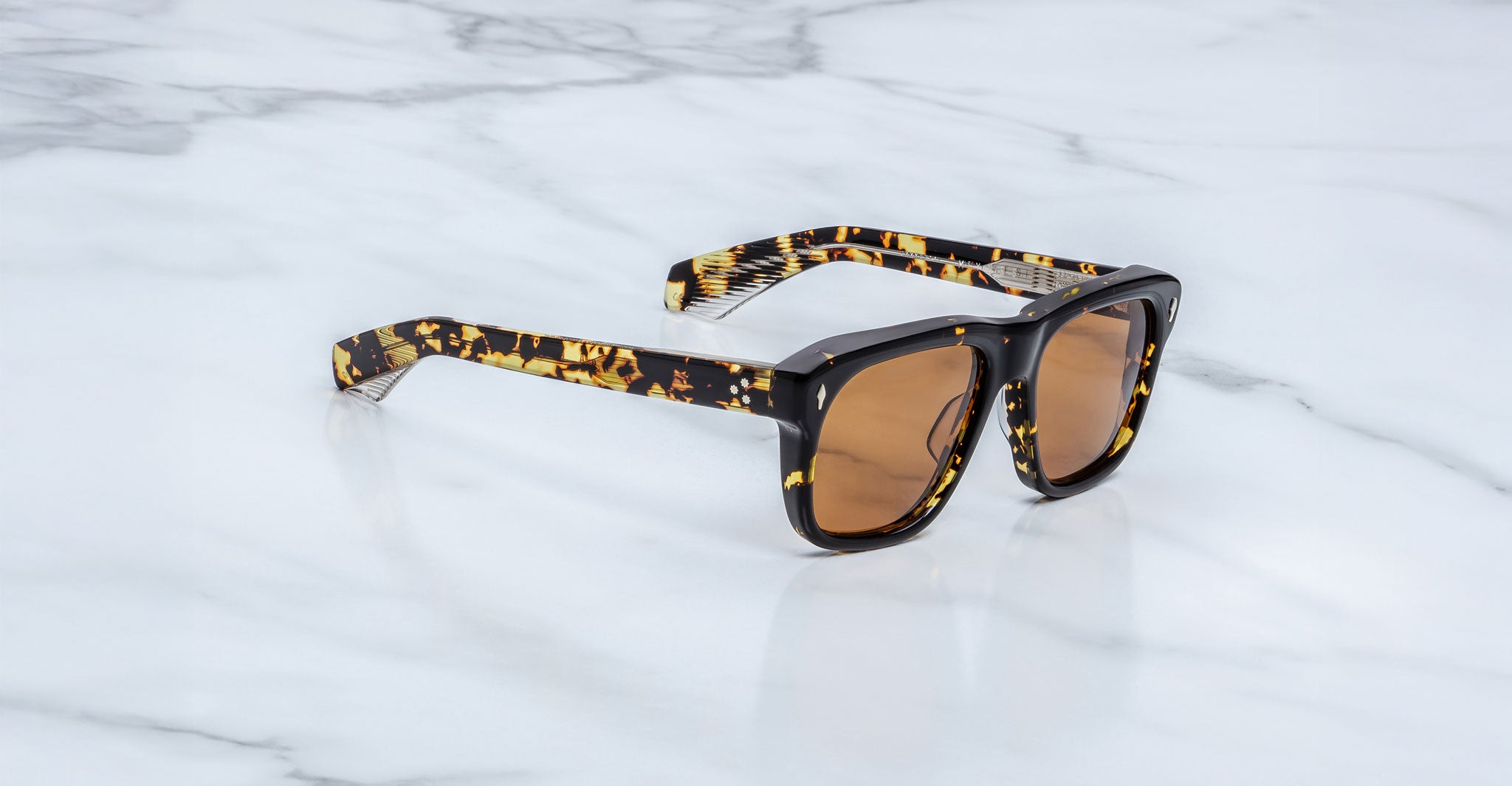 Jacques Marie Mage Yves in Tokyo sunglasses, rectangular black acetate frame with yellow tortoise pattern and amber-tinted lenses, signature arrowhead rivets, angled side view
