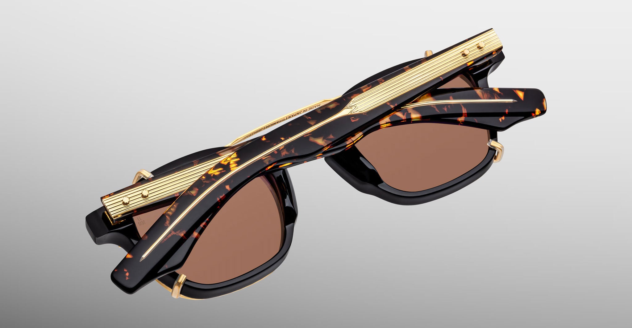 Jacques Marie Mage Zephirin 47 Clip On 2 sunglasses with gold accents, folded and shown from a top-down perspective.