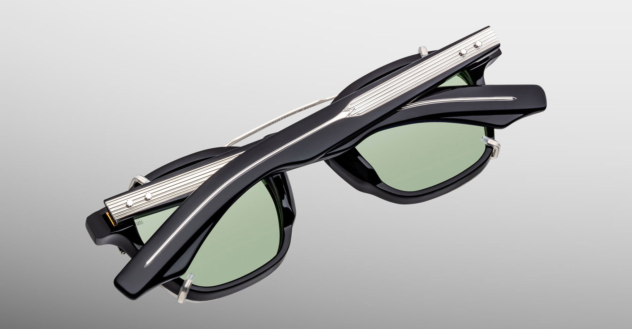 Jacques Marie Mage Zephirin 47 Clip On 2 black sunglasses with green lenses, folded, front view.