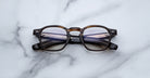 Jacques Marie Mage Zephirin 47 round eyeglasses in brown and black, front view.