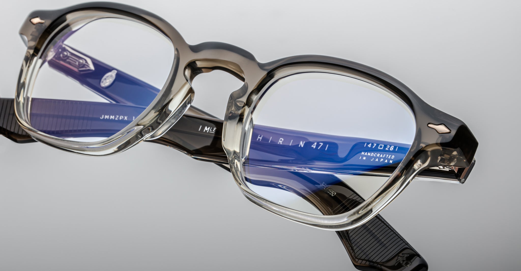 Close-up of Jacques Marie Mage Zephirin 47 eyeglasses in clear and blue acetate, showing inner arm brand markings.