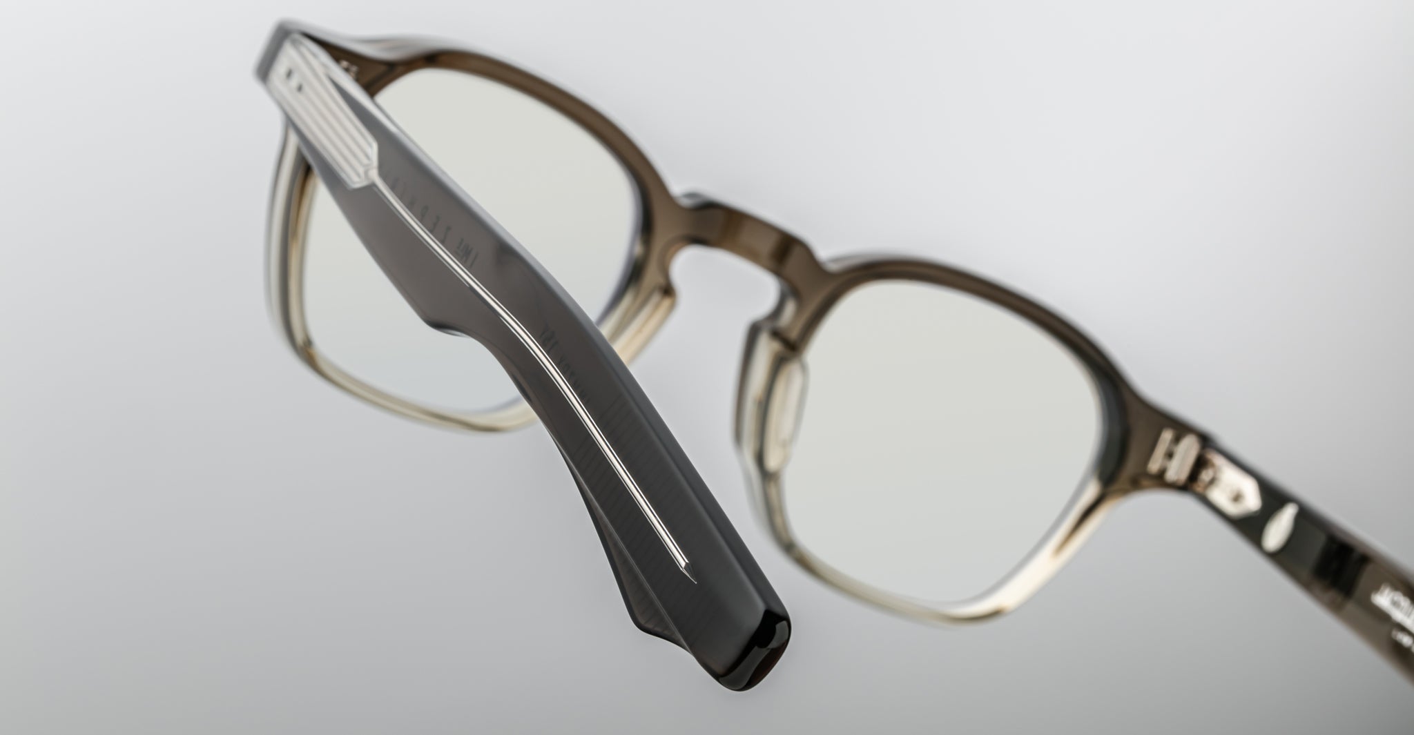 Close-up of Jacques Marie Mage Zephirin 47 eyeglasses featuring translucent brown thick frames and bold silver temple accents.
