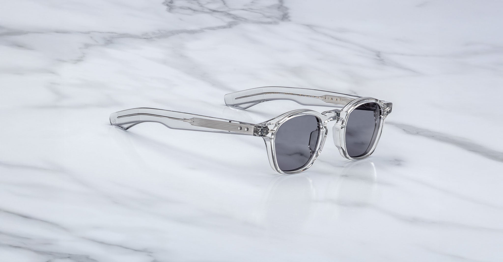 Jacques Marie Mage Zephirin 47 clear-framed polarized sunglasses with dark lenses, front view.