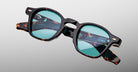Jacques Marie Mage Zephirin sunglasses in Aegen, angled detail view with turquoise lenses and tortoiseshell acetate accents.