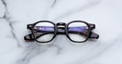 Jacques Marie Mage Zephirin optical frame in Aegen, front view with clear lenses, dark tortoiseshell acetate, and gold-tone accents.