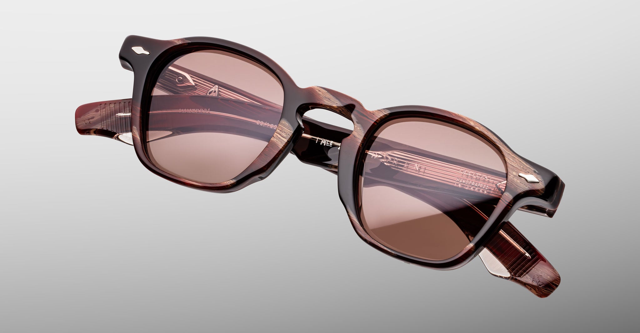 Jacques Marie Mage Zephirin sunglasses in Auburn, angled front detail with reddish-brown marbled acetate, rose-tinted lenses, and silver-tone accents.