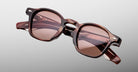 Jacques Marie Mage Zephirin sunglasses in Auburn, angled front detail with reddish-brown marbled acetate, rose-tinted lenses, and silver-tone accents.