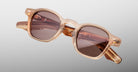 Jacques Marie Mage Zephirin sunglasses in Casliza, angled front detail with translucent amber acetate and rose-tinted lenses.