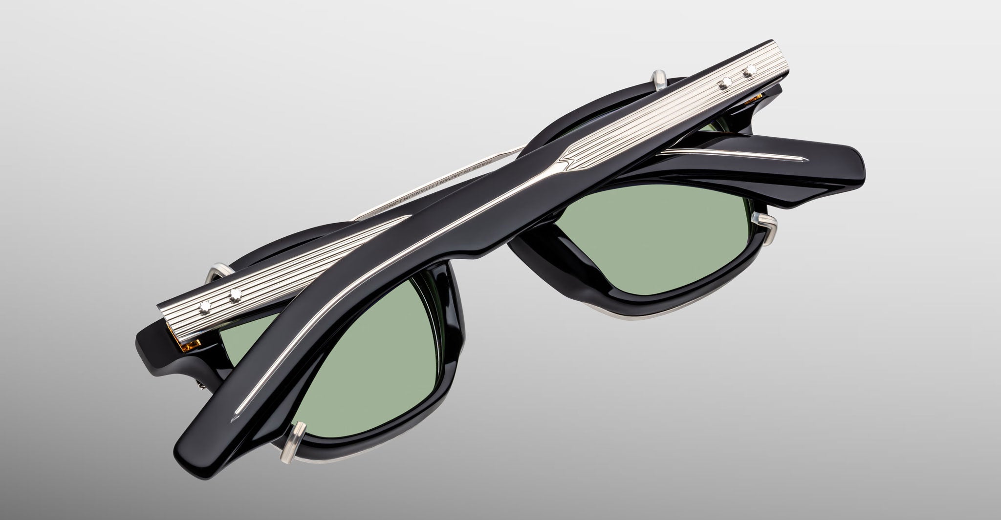 Jacques Marie Mage Zephirin Clip On 2 sunglasses with green lenses, folded, front-facing.
