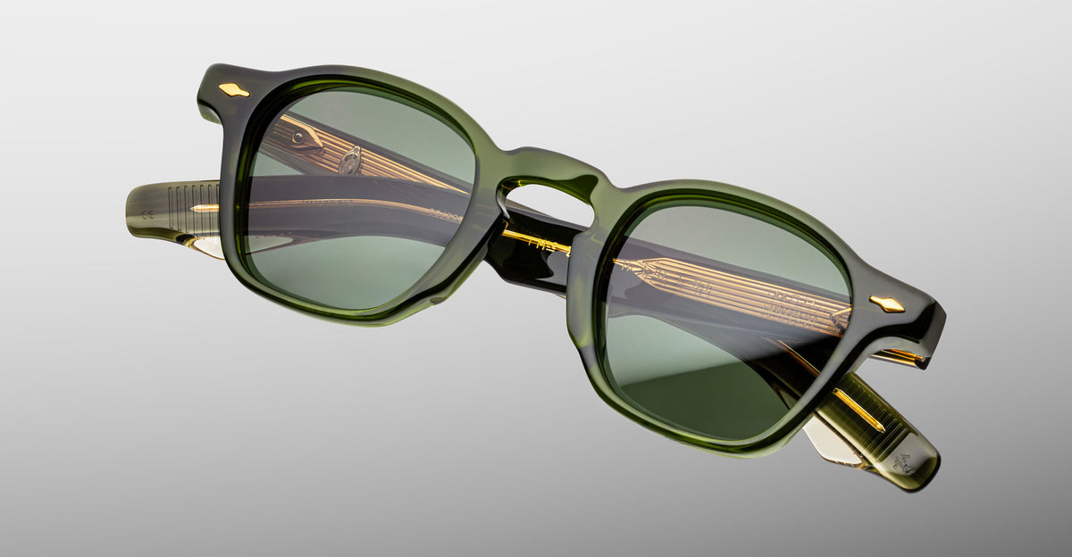 Jacques Marie Mage Zephirin sunglasses in Kombu, angled front detail with translucent olive green acetate, green-tinted lenses, and gold-tone accents.