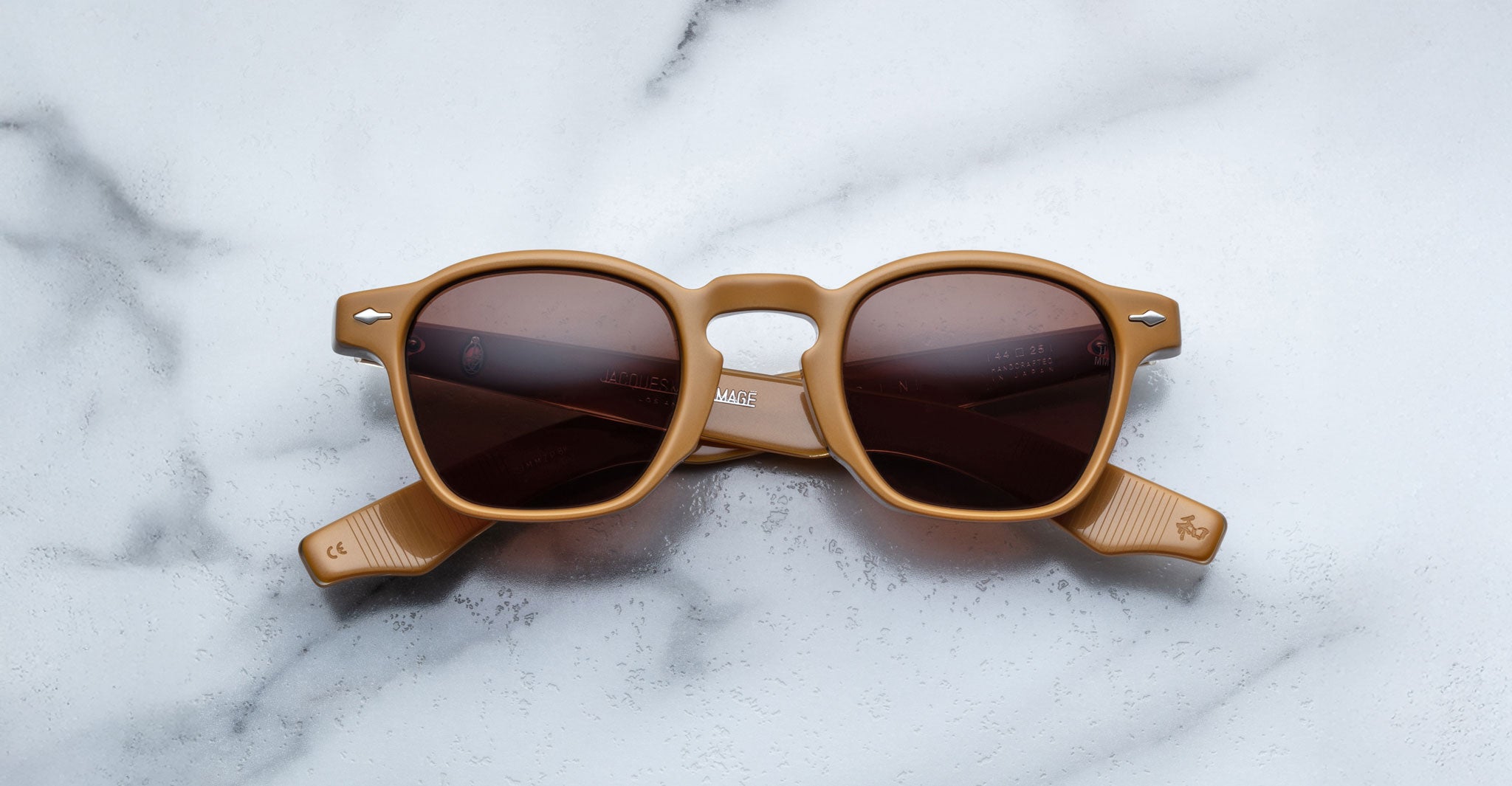 Jacques Marie Mage Zephirin: limited edition light brown handcrafted acetate spectacles with dark lenses, inspired by Jacques Marie Mage, displayed on white marble—a true eyewear statement piece.