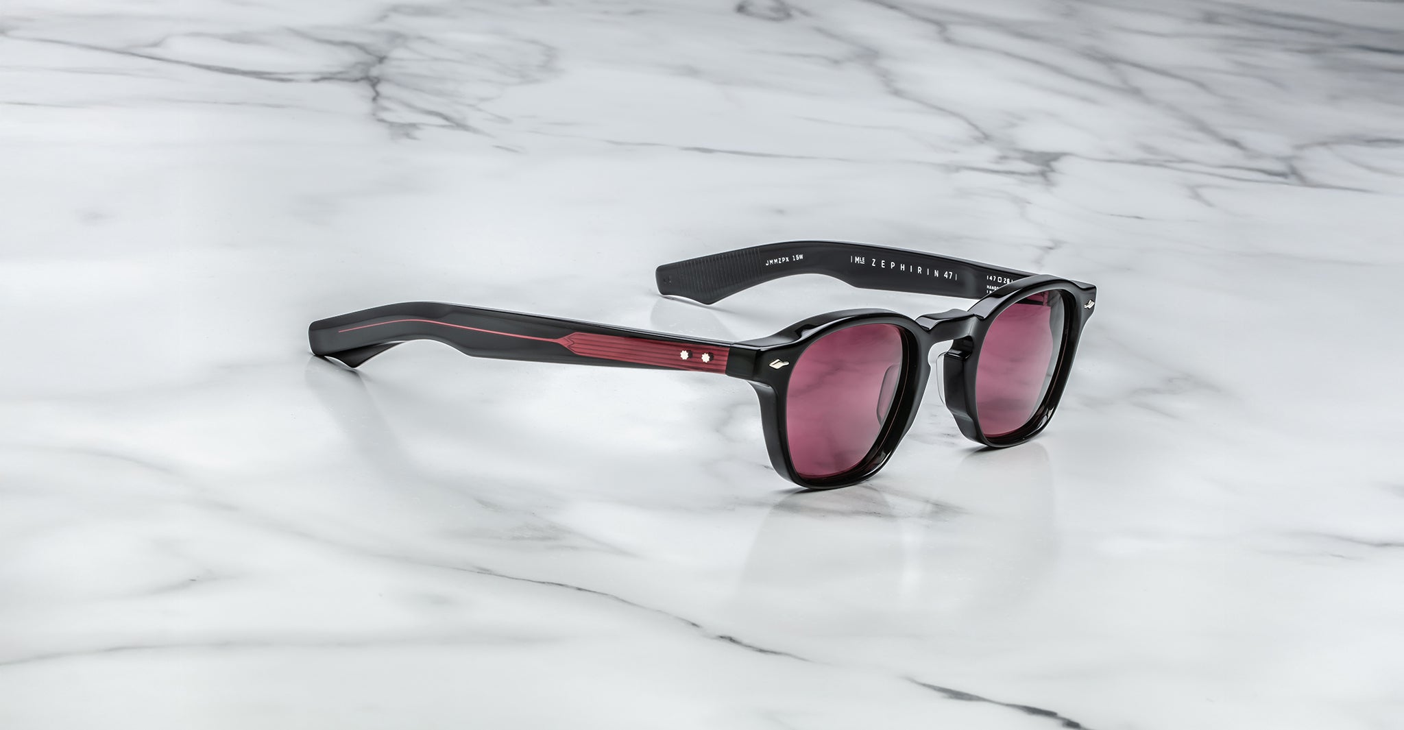 Jacques Marie Mage Zephirin 47 sunglasses with red arms and tinted lenses shown from above.