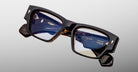 Jacques Marie Mage Agar optical glasses in dark tortoise acetate with bold rectangular frame, clear lenses, and signature arrowhead front pins, angled front view