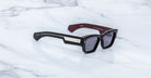Jacques Marie Mage Zimmerman sunglasses in Bloodstone black acetate with bold rectangular frame, dark tinted lenses, and wide temples with signature metal core detail, angled view