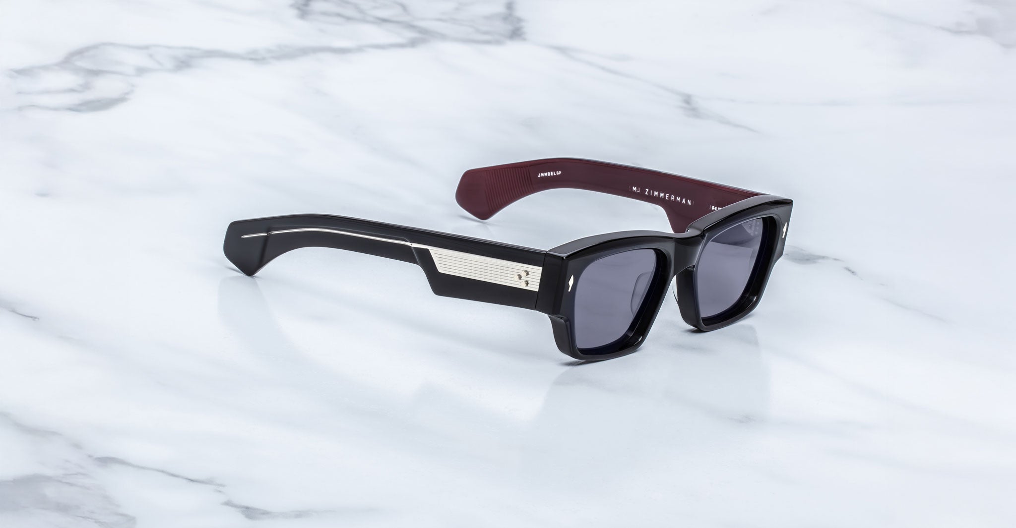 Jacques Marie Mage Zimmerman sunglasses in Bloodstone black acetate with bold rectangular frame, dark tinted lenses, and wide temples with signature metal core detail, angled view