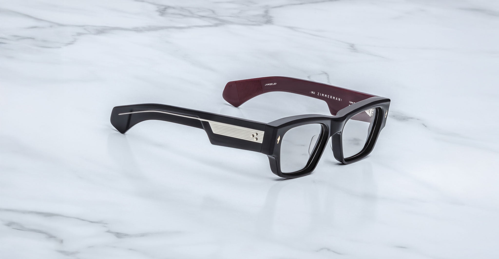 Jacques Marie Mage Zimmerman optical glasses in Bloodstone black acetate with bold rectangular frame, clear lenses, and wide temples with signature metal core detail, angled view