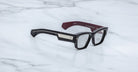 Jacques Marie Mage Zimmerman optical glasses in Bloodstone black acetate with bold rectangular frame, clear lenses, and wide temples with signature metal core detail, angled view